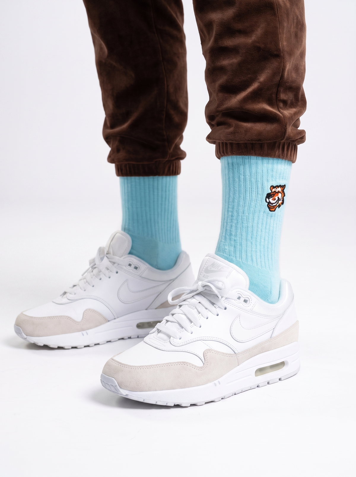 Flight Mode Crew-Socken in Türkis von Good Willy zu weißen Sneakern und brauner Jogginghose (KI-generiert)