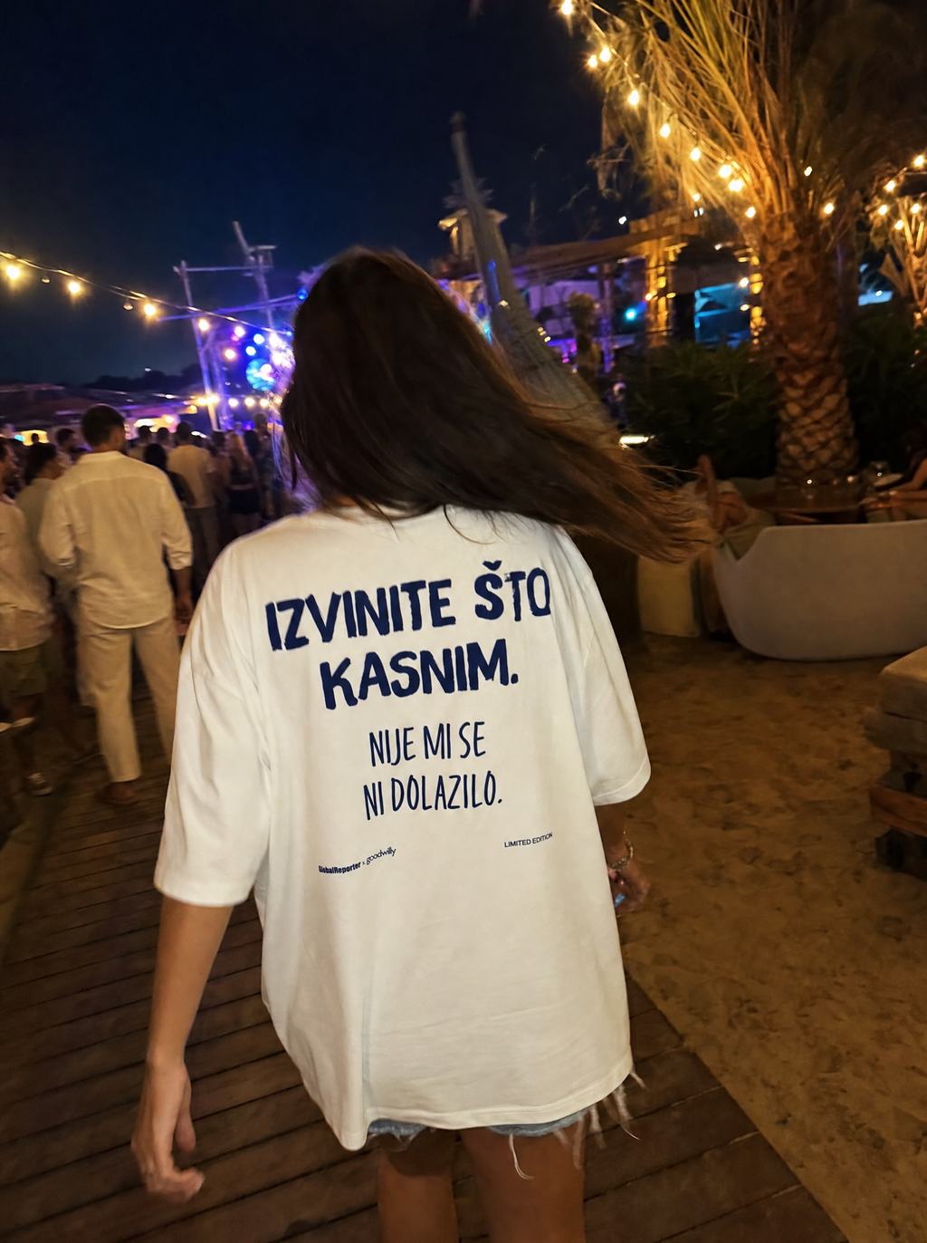 Izvinite što kasnim T-Shirt von Good Willy, getragen von einer Frau abends in der Stadt, Rückansicht (KI-generiert)
