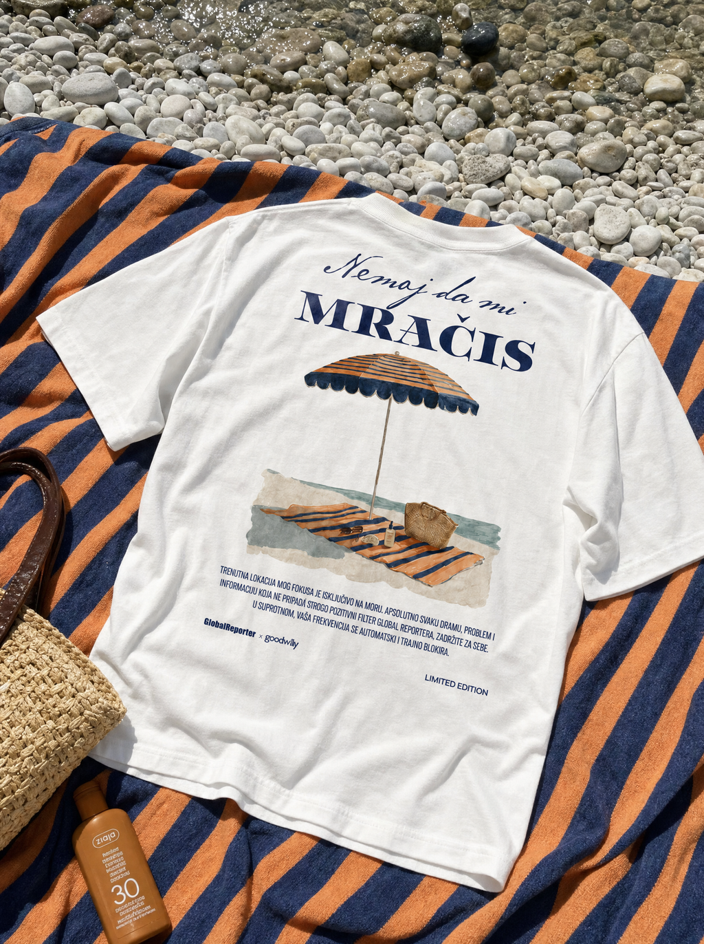 Nemoj da mi mračiš T-Shirt von Good Willy, flach liegend auf einem gestreiften Strandtuch (KI-generiert)