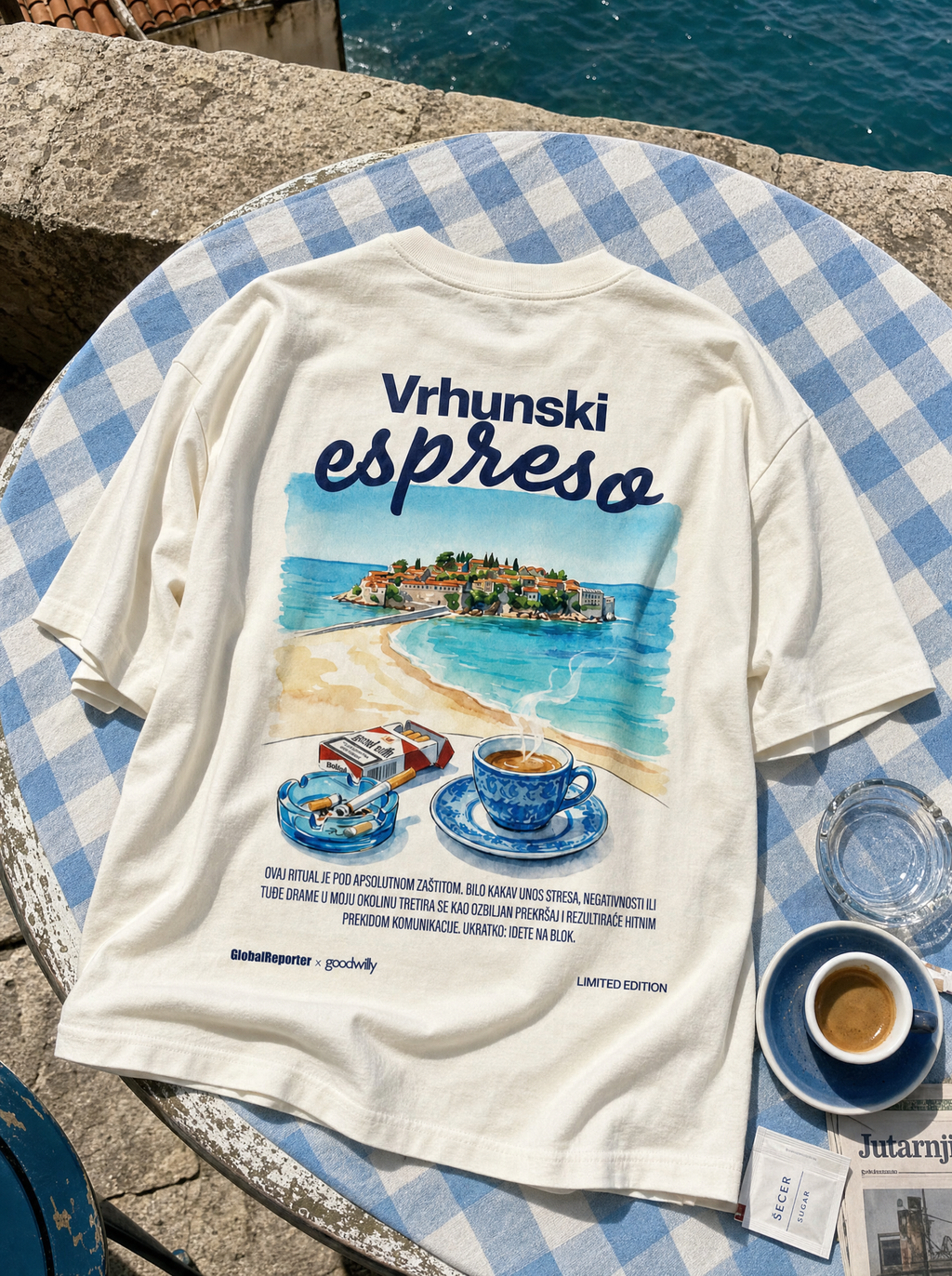 Vrhunski espreso T-Shirt von Good Willy, flach liegend auf einem blau karierten Tischtuch neben einem Espresso (KI-generiert)